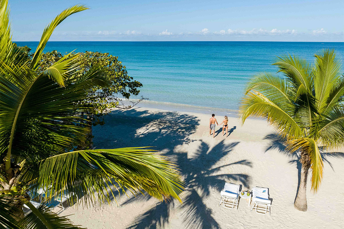 aerial shot of couple walking on the beach