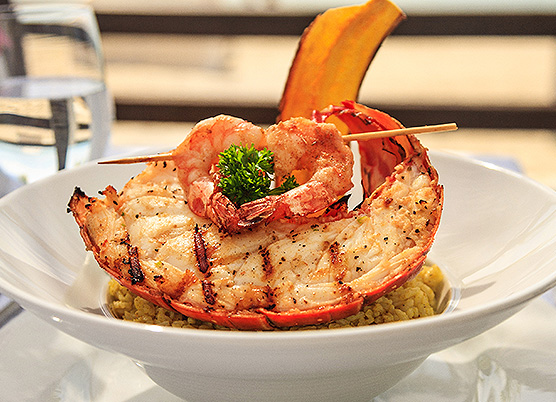 lobster topped with shrimp in a bowl of rice
