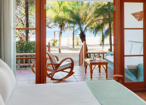 a veranda with chairs and a beach view