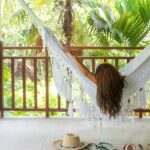 behind view of a woman laying on a hammock on a private balcony